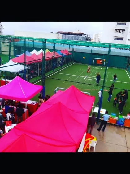 This aerial view demonstrates my capability in setting up for large outdoor events. I organized this preschool carnival in Whitefield with multiple colorful tents for various activities and stalls, all arranged on a professional sports ground.
