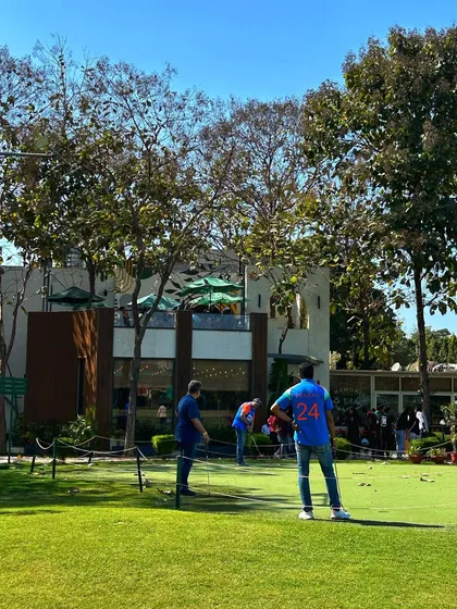 Friends gather on the putting green in front of the cafe, enjoying the social side of golf.