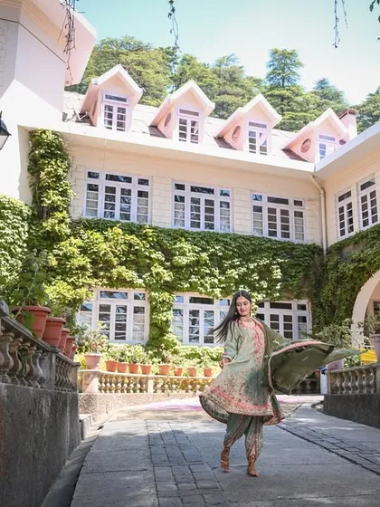 A wide shot showing the bride twirling in front of the magnificent Woodville Palace during her Mehandi function.