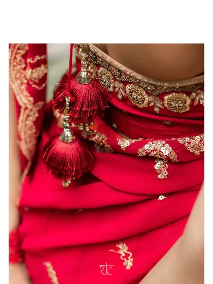 A close-up of the sequined scalloped dupatta and the intricate zardosi beadwork on the maroon blouse, complete with elegant tassels.