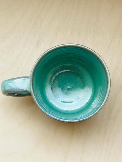 The Flow Mug from above, revealing the vibrant, glossy teal glaze on the inside. It’s like a hidden pool of calm.