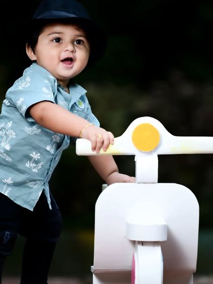 Another shot of the baby boy on his scooter, this time with a happy, open-mouthed expression.