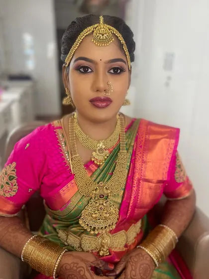 My beautiful bride Lakshmi Priya, ready for her Muhurtham in Karur. Her look is a classic example of South Indian bridal beauty, with bold eyes, a vibrant lip colour, and layers of traditional gold jewellery.