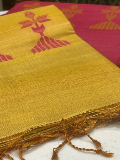 A glimpse into our diverse saree collection, featuring a mustard yellow and a bright pink saree, both with unique woven motifs and tassel details.
