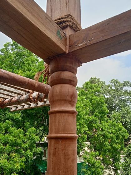 A close-up of a restored timber column, showcasing the turned details that are characteristic of colonial-era Indian architecture.