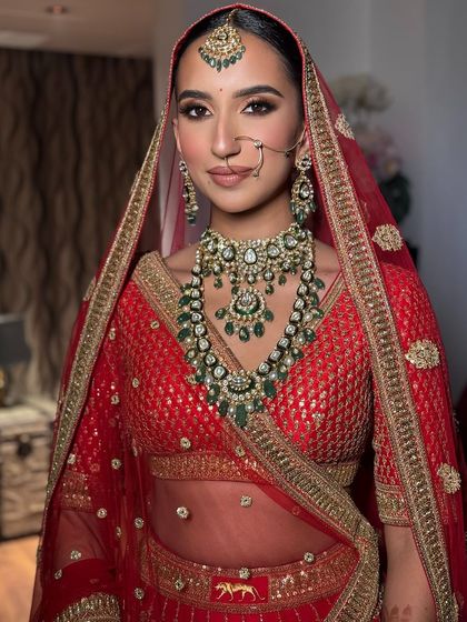 A stunning bride with her hair in a sleek bun, adorned with flowers for her wedding day.
