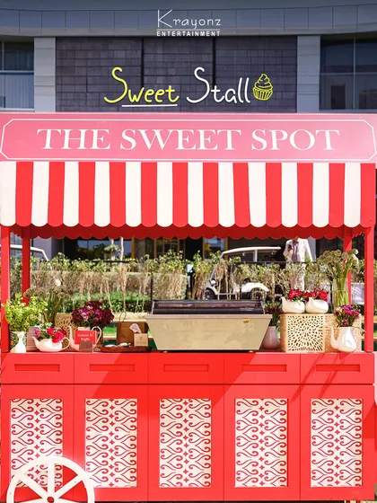 A charming "Sweet Spot" stall, designed like a vintage cart, offering delicious treats to guests. It's a delightful detail that adds to the festive atmosphere.