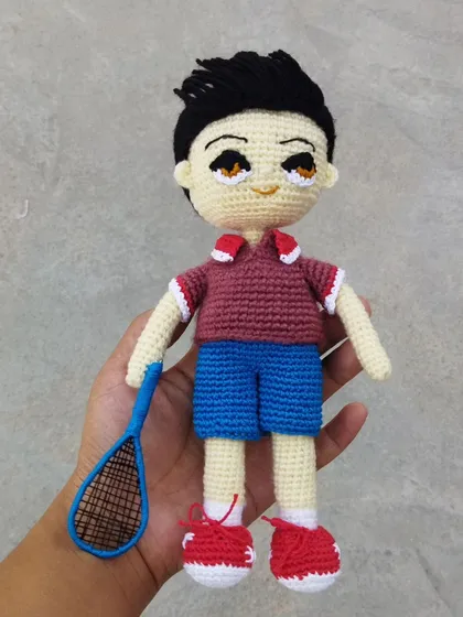 Another angle of the custom badminton player doll, showing the texture of the yarn and the careful construction of his athletic outfit.