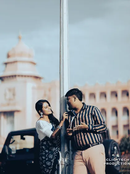 A playful interaction between the couple in front of the Vidhana Soudha, with a vintage color treatment enhancing the mood.