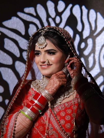 An artistic shot using shadows to create a dramatic effect. Even in unique lighting, the makeup remains on point, highlighting her beautiful features.