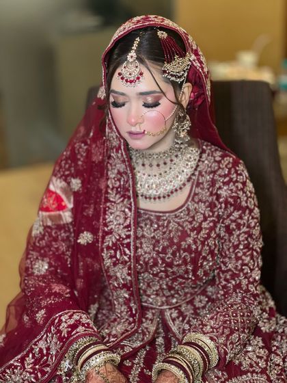 A beautiful seated portrait of the Nikkah bride. Her makeup features soft glitter on the eyes and a flawless complexion, creating a dreamy and romantic look.