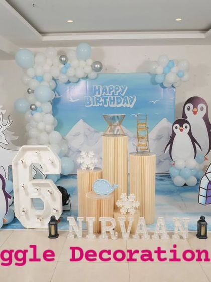 A cool and unique penguin-themed 6th birthday party. I created a winter scene with an igloo cutout, penguin characters, and a balloon garland in shades of icy blue and white.