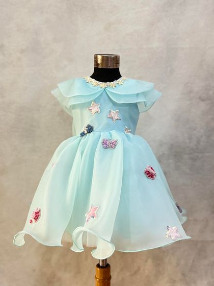 Another view of this custom aqua organza dress, highlighting the delicate collar and whimsical star embellishments.