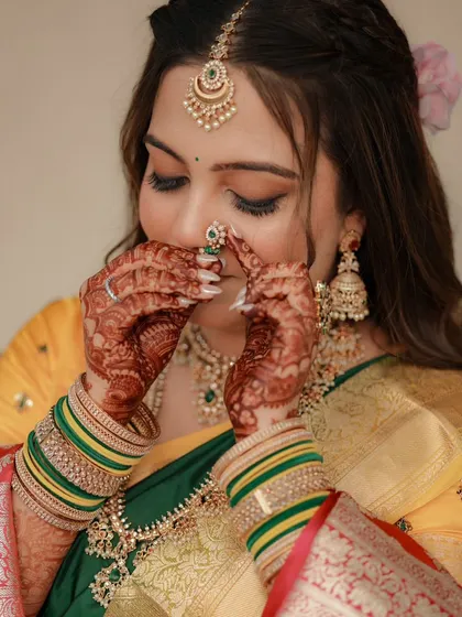 A playful pose from the bride, highlighting her flawless makeup and the deep color of her mehendi.