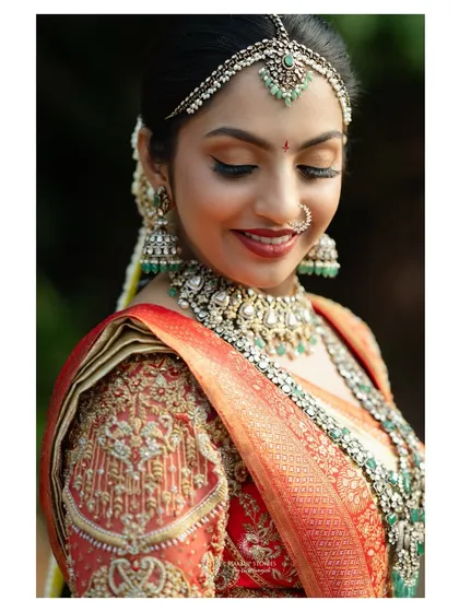 A serene moment captured. The soft shimmer on the eyelids and the perfectly blended base makeup ensure the bride looks ethereal and divine, whether her eyes are open or closed.