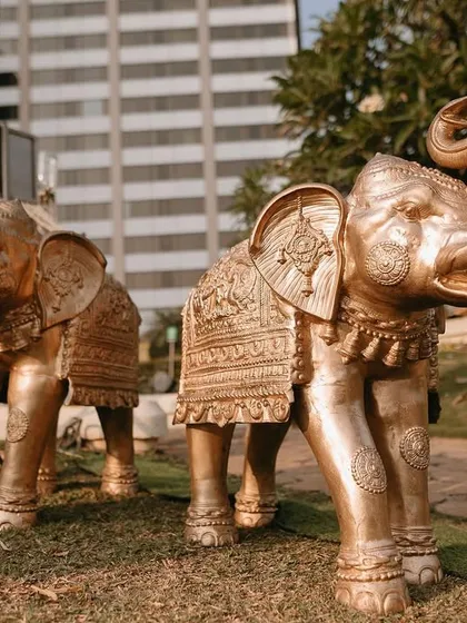 Majestic elephant statues with intricate carvings, used as symbolic and grand decor elements for a traditional wedding entrance.