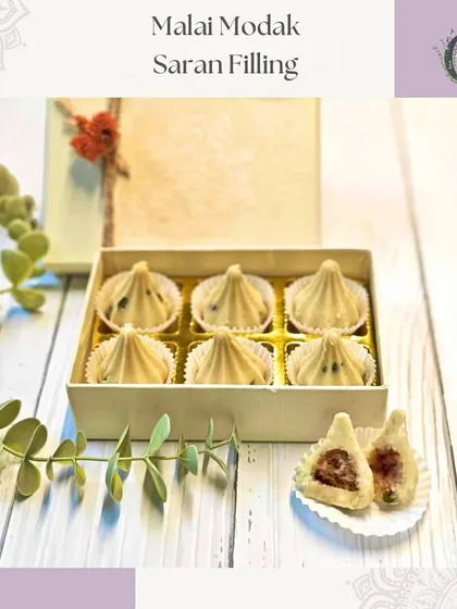 Our Malai Modak with a traditional 'saran' filling. These sweets combine classic flavors with an elegant presentation.