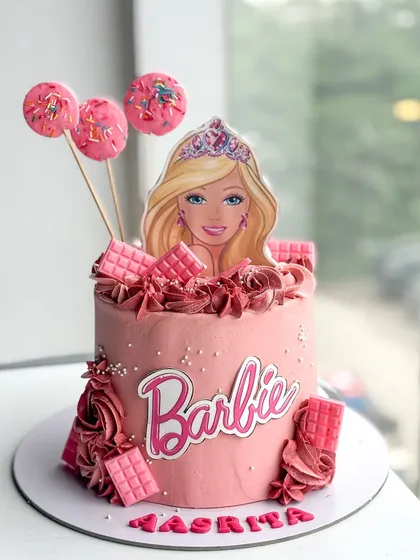Come on Barbie, let's go party! This Barbie-themed cake was a total blast to make. It's a pink buttercream dream, complete with a custom Barbie topper, fun cakesicles, and little chocolate bar details. A perfect centerpiece for a trendy kid's birthday party.