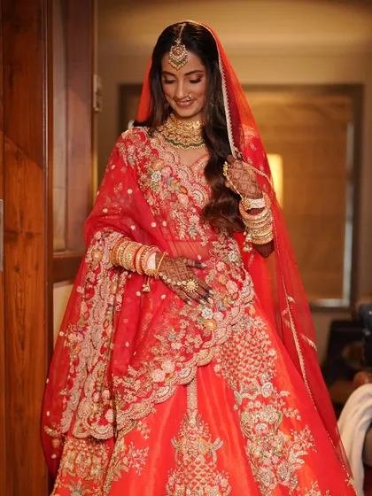 A beautiful shot of the bride getting ready, her expression full of anticipation. The soft waves in her hair and the glowing makeup create a romantic and modern bridal look.