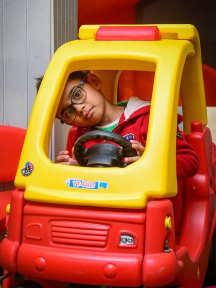 A thoughtful moment behind the wheel. Our ride-on car is a popular spot for kids to sit and imagine their own road trips.