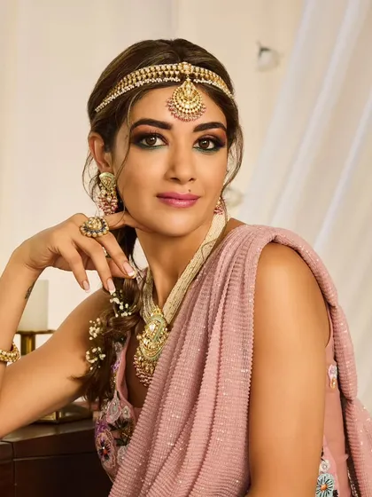 A bohemian-inspired bridal braid. This loose, textured braid is woven with baby's breath and paired with a sheeshpatti for a look that is perfect for a Mehendi or a relaxed outdoor wedding.