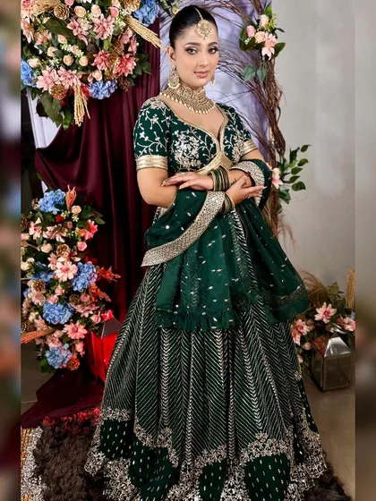 Another pose in the beautiful green lehenga, highlighting the intricate work on the skirt.