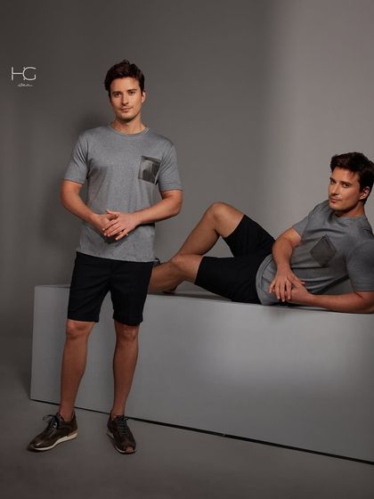 This look elevates everyday casuals with refinement. A simple grey t-shirt with a contrasting pocket detail is paired with black shorts for a stylish and comfortable outfit.