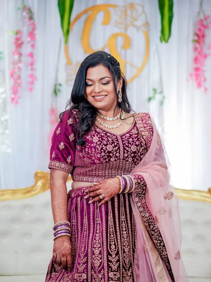 A candid, smiling photo of the bride. Her makeup looks fresh and beautiful, enhancing her natural features for her special day.