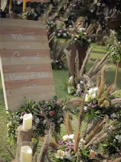 A rustic wooden welcome sign for the carnival of Vismay and Aditi. Surrounded by pampas grass and wildflowers, it set a warm and inviting tone for their nature-inspired celebration.