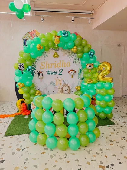A view of the jungle theme setup with a balloon-covered table ready for the cake.