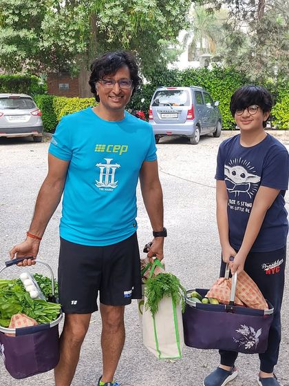 A father and son duo with their baskets full of fresh produce, showing the family-friendly nature of the market.