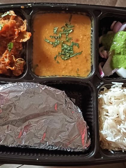 A unique thali featuring dal and kathal (jackfruit) sabzi. Kathal is cooked in a flavorful gravy that tastes almost like meat.