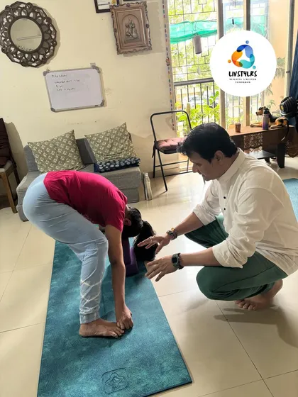 I believe in a hands-on approach. Here, I'm guiding a client to ensure proper alignment in a forward bend, which is crucial for preventing injury and maximizing the benefits of the pose. This personal attention is at the core of my coaching philosophy.