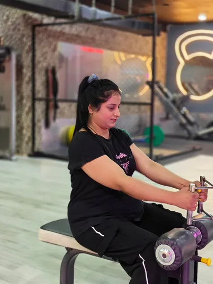 A client works on her back strength using the seated row machine. Our gym has a variety of machines and free weights to target every muscle group effectively and safely.