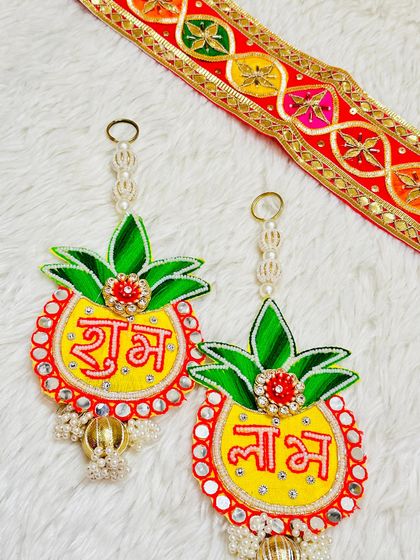 A pineapple-shaped Shubh Labh hanging that is both fun and auspicious. The yellow and green design with mirror work is a unique addition to any festive decor.