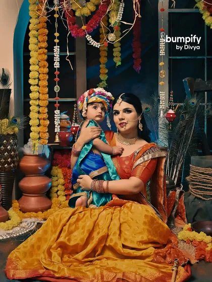A full portrait of mother and son as Yashoda and Krishna, showcasing the beautiful traditional attire and the vibrant festive setup.