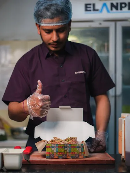 Chef-approved and ready to be savored. Our chef gives a thumbs-up as he packs a freshly made sandwich, a sign that it's good to go.
