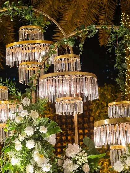 A close-up of the custom-made crystal light fixtures, which were designed to look like miniature chandeliers, adding a touch of glamour to the floral backdrop.