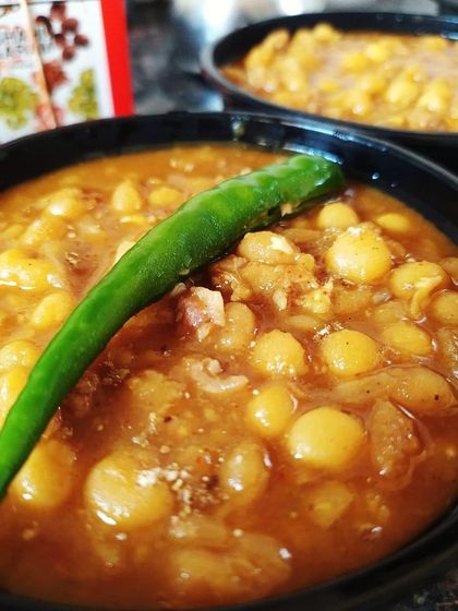 Maangsher Ghugni, a popular Kolkata street food snack. This is a spicy yellow pea curry spiked with minced mutton, perfect for warming up on a chilly evening and bringing back memories of Kolkata's fairs.