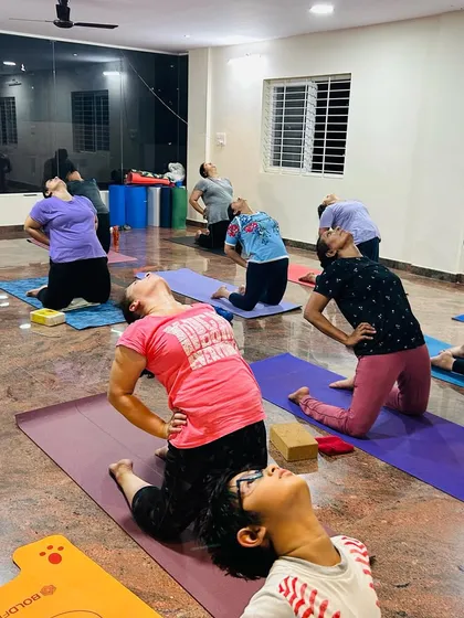 Students in Ustrasana, or Camel Pose, a deep backbend that opens the heart and stretches the entire front of the body. I guide everyone to practice at a level that feels right for them.