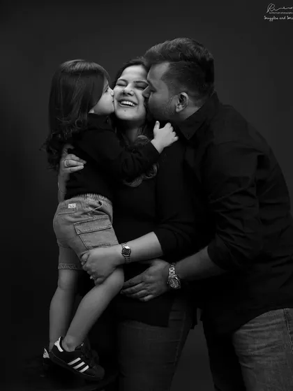 Welcoming a new baby is a family affair. This black and white portrait captures the pure, unscripted love and excitement between a mother, father, and soon-to-be big sister.