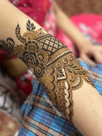 A detailed shot of the armband on Afnaz's Pakistani bridal henna, showcasing the combination of floral and geometric elements.