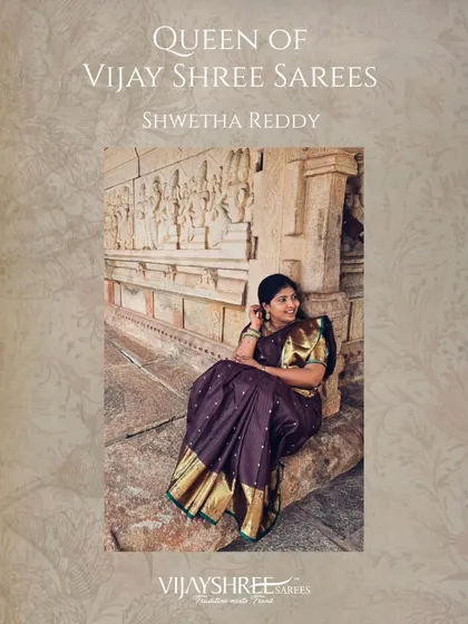 Shwetha Reddy, one of our cherished 'Queens', looks regal in a deep purple Kanjivaram silk saree with a classic gold border, pictured against a backdrop of heritage architecture.