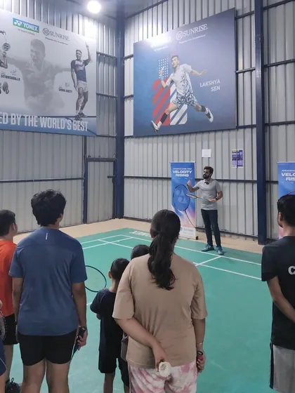 A group of my students listening intently as I explain the features of a new racket during the Yonex Demo Day. I believe in educating my players about their equipment to help them make informed choices.