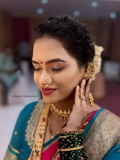 A shy, smiling pose that shows off the intricate details of the makeup and jewellery. The look is timeless and elegant.