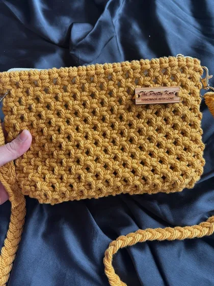 This mustard yellow macrame sling bag is perfect for your everyday look. It's affordable, sturdy, and features a secure zipper and a detachable strap.