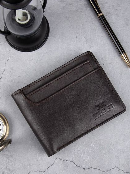 A styled shot of the dark brown wallet with classic props.