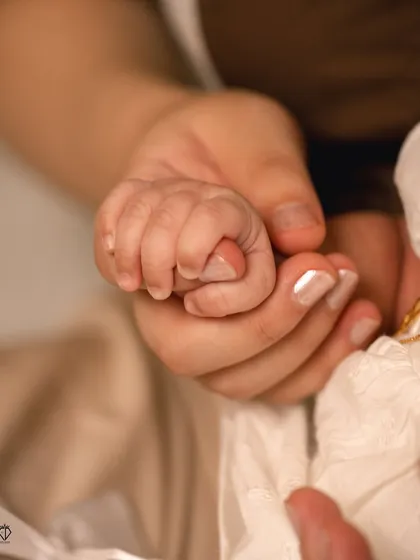 Sometimes the smallest details tell the biggest story. A newborn's tiny hand grasping her mother's finger is a powerful symbol of their new bond, a detail I always look for in my family sessions.