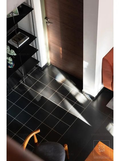 The play of sunlight on the dark tiled floor creates a beautiful, ephemeral pattern, highlighting the importance of natural light in the design.