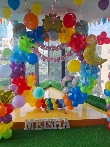 A full view of the rainbow party, showing the moon and heart-shaped balloons that add to the cheerful atmosphere.